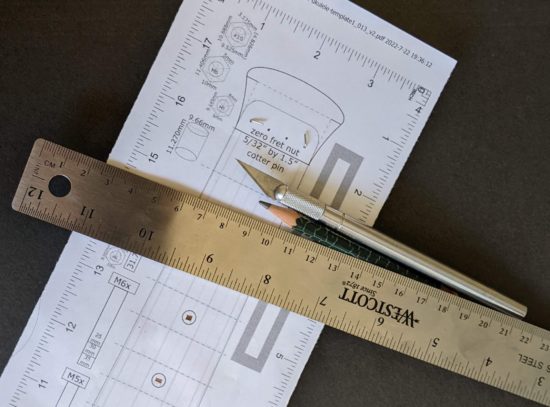 Using a ruler and a pencil to draw in the fret marker locations
